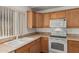 Well-lit kitchen featuring wood cabinets, tiled countertops, and modern appliances for a functional cooking space at 2794 E Cowboy Cove Trl, San Tan Valley, AZ 85143