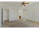 Bright bedroom with neutral carpet, ceiling fan, and a doorway leading to the ensuite bathroom at 2932 N 115Th Ln, Avondale, AZ 85392