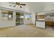Bright, open-concept living room featuring neutral carpet, multiple windows and access to a kitchen at 2932 N 115Th Ln, Avondale, AZ 85392
