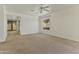 Bright, carpeted living room featuring ceiling fan and access to the backyard through sliding glass doors at 2932 N 115Th Ln, Avondale, AZ 85392