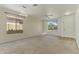 Bright, spacious living room featuring carpet, large windows, a ceiling fan, and a modern light fixture at 2932 N 115Th Ln, Avondale, AZ 85392