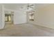 Bright, carpeted living room with ceiling fan and sliding glass doors to the backyard at 2932 N 115Th Ln, Avondale, AZ 85392
