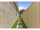 A paved walkway with artificial turf between two homes and leading to a backyard gate at 2932 N 115Th Ln, Avondale, AZ 85392