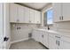 Bright laundry room featuring white cabinets and modern black hardware at 31505 N 166Th Pl, Scottsdale, AZ 85262