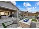 Beautiful backyard featuring a stone fire pit, Adirondack chairs, a covered patio and outdoor seating near a spa at 32268 N 133Rd Ln, Peoria, AZ 85383