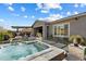 Beautiful backyard with a hot tub, outdoor kitchen, and tiled patio at 32268 N 133Rd Ln, Peoria, AZ 85383