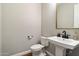 Powder room featuring a pedestal sink, black hardware, and a modern gold mirror at 32268 N 133Rd Ln, Peoria, AZ 85383