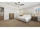 Serene bedroom with plantation shutters, neutral walls, and a decorative ceiling fan, offering a peaceful retreat at 32268 N 133Rd Ln, Peoria, AZ 85383
