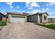 Exterior view of a home with a three-car garage and desert landscaping at 32268 N 133Rd Ln, Peoria, AZ 85383
