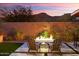 Cozy backyard seating area with a fire pit and desert views at sunset at 32268 N 133Rd Ln, Peoria, AZ 85383
