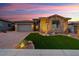 Charming home exterior featuring a stone facade, well-manicured lawn, and a paved driveway at 32268 N 133Rd Ln, Peoria, AZ 85383