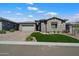 Charming home with a well-maintained lawn, stone accents, and a paved driveway leading to a two-car garage at 32268 N 133Rd Ln, Peoria, AZ 85383