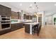 Beautiful kitchen features granite counters, stainless appliances, a spacious island with pendant lights, and hardwood floors at 32268 N 133Rd Ln, Peoria, AZ 85383