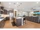Open concept kitchen with an island, stainless steel appliances, hardwood floors, and seamless flow into the living area at 32268 N 133Rd Ln, Peoria, AZ 85383
