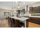 Modern kitchen featuring an island with seating, stainless steel appliances, and stylish pendant lighting at 32268 N 133Rd Ln, Peoria, AZ 85383