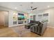 Relaxing living room showcasing plantation shutters, hardwood floors, ceiling fan, and a built-in entertainment center at 32268 N 133Rd Ln, Peoria, AZ 85383