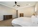 Spacious main bedroom with tray ceiling, ceiling fan, and dark wood furniture set at 32268 N 133Rd Ln, Peoria, AZ 85383