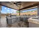 A fully equipped outdoor kitchen featuring a grill, stainless steel appliances, and countertop space under a covered patio at 32268 N 133Rd Ln, Peoria, AZ 85383