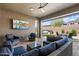 Inviting covered patio with comfortable seating, a TV, and a view of the outdoor fire pit and spa at 32268 N 133Rd Ln, Peoria, AZ 85383