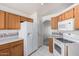 Cozy kitchen with light wood cabinets, white appliances, and tile flooring at 3349 E Lavey Ln, Phoenix, AZ 85032