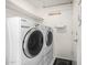 Laundry room with washer and dryer, storage shelf, and tile floors at 3349 E Lavey Ln, Phoenix, AZ 85032