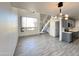 Open living space with modern light fixture, tiled floor, staircase, and kitchen at 3646 N 69Th Ave # 70, Phoenix, AZ 85033