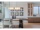 Elegant dining area with a modern light fixture, mirrored wall art, and a built-in cabinet with glass doors at 37200 N Cave Creek Rd # 1019, Scottsdale, AZ 85262