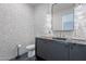 Stylish powder room with geometric tile, modern vanity, and a sleek, round mirror at 37200 N Cave Creek Rd # 1019, Scottsdale, AZ 85262