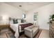 Bright bedroom featuring white walls, a metal bed frame, colorful pillows, and an attached bathroom at 37200 N Cave Creek Rd # 1034, Scottsdale, AZ 85262