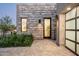 Contemporary home exterior featuring a stone facade, modern lighting, and glass garage door at 37200 N Cave Creek Rd # 1034, Scottsdale, AZ 85262