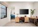 Bright office space with a desk, TV, and a view to a bedroom at 37200 N Cave Creek Rd # 1034, Scottsdale, AZ 85262