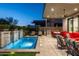 Inviting backyard oasis featuring a sparkling pool with waterfalls, and covered patio with dining and lounge areas at 37200 N Cave Creek Rd # 1034, Scottsdale, AZ 85262