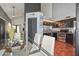 Open-concept kitchen and dining area with a glass table, black cabinets, and stainless steel appliances at 3827 N 88Th Ln, Phoenix, AZ 85037