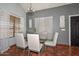 Dining room featuring a glass table, modern chandelier, and neutral color palette at 3827 N 88Th Ln, Phoenix, AZ 85037