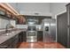 Kitchen with stainless steel appliances, dark cabinets, and tile flooring at 3827 N 88Th Ln, Phoenix, AZ 85037