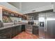 Kitchen featuring stainless steel appliances, dark cabinets, and tile flooring at 3827 N 88Th Ln, Phoenix, AZ 85037