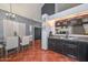Open concept kitchen and dining area featuring a glass table and dark wooden cabinets at 3827 N 88Th Ln, Phoenix, AZ 85037