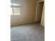 Neutral bedroom featuring plush carpet, a sunlit window, and a convenient closet at 4136 N 113Th Dr, Phoenix, AZ 85037