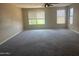 Spacious living room with plush carpeting and a ceiling fan offers comfort and style for relaxing or entertaining at 4136 N 113Th Dr, Phoenix, AZ 85037