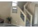 Modern staircase with carpet, glass railing, and a plant adds a clean style to the home's interior at 4136 N 113Th Dr, Phoenix, AZ 85037