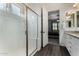 Bathroom showcasing a tiled shower, white cabinetry, granite countertops, and wood-look flooring at 4361 S Electron --, Mesa, AZ 85212