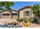 Charming home with a three-car garage and desert landscaping with yellow flowers at 4361 S Electron --, Mesa, AZ 85212