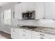 Well-appointed kitchen with granite countertops, a gas cooktop, stainless steel microwave, and white cabinetry at 4361 S Electron --, Mesa, AZ 85212