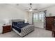 Comfortable main bedroom features a ceiling fan, plush carpeting, and dual windows with decorative curtains at 4361 S Electron --, Mesa, AZ 85212
