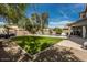 Expansive backyard featuring a well-maintained lawn, sparkling pool, and covered patio, perfect for outdoor living at 44566 W High Desert Trl, Maricopa, AZ 85139