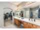 Bright bathroom with dual sinks, vanity, and access to a closet at 44566 W High Desert Trl, Maricopa, AZ 85139