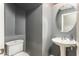 Cozy half bathroom with a pedestal sink and gray walls at 44566 W High Desert Trl, Maricopa, AZ 85139