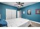 Blue bedroom with closet and ceiling fan at 44566 W High Desert Trl, Maricopa, AZ 85139