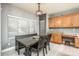Charming dining area with a modern chandelier, dining table, and large bright window at 44566 W High Desert Trl, Maricopa, AZ 85139
