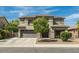 Two-story home featuring desert landscaping, a wide driveway, and neutral-tone exterior at 44566 W High Desert Trl, Maricopa, AZ 85139
